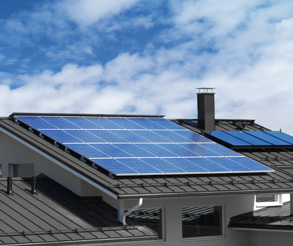 Modern house with rooftop solar panels under a partly cloudy blue sky, showcasing clean energy technology.
